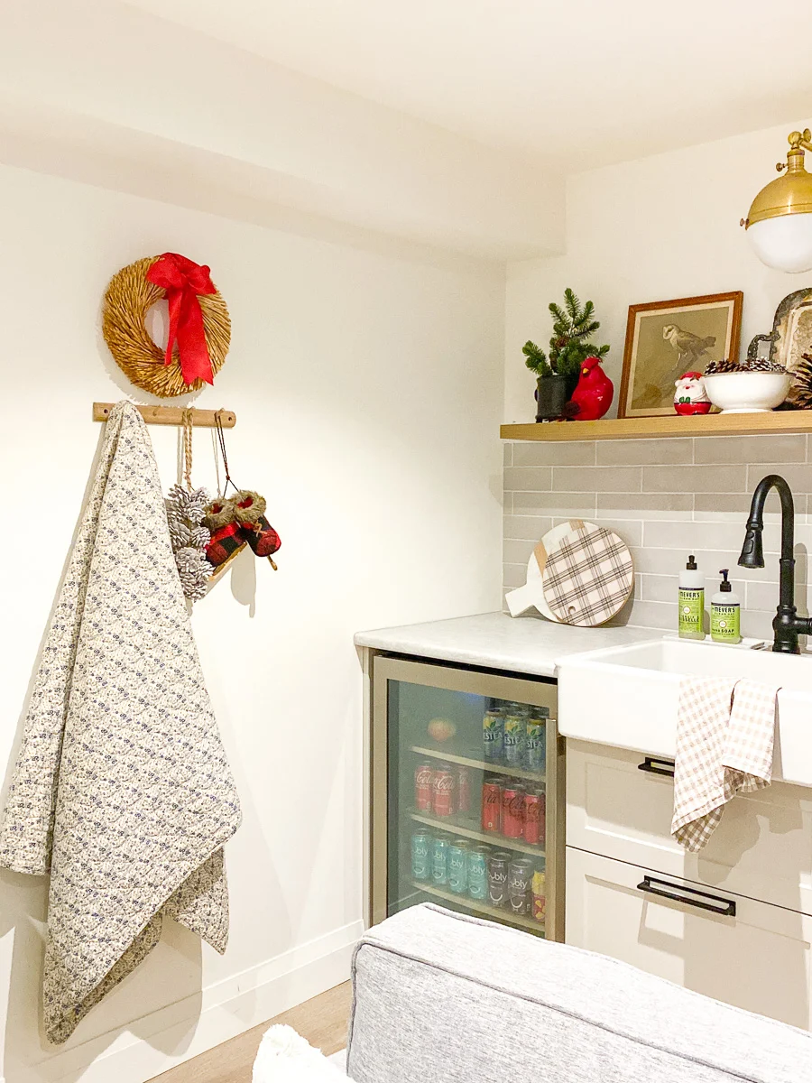 basement kitchenette with peg rail, farmhouse sink, and floating shef