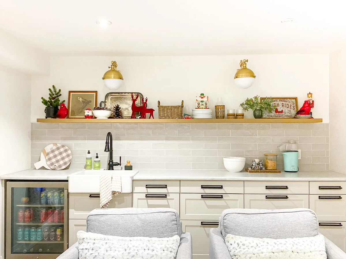 basement kitchenette with peg rail, farmhouse sink, and floating shef