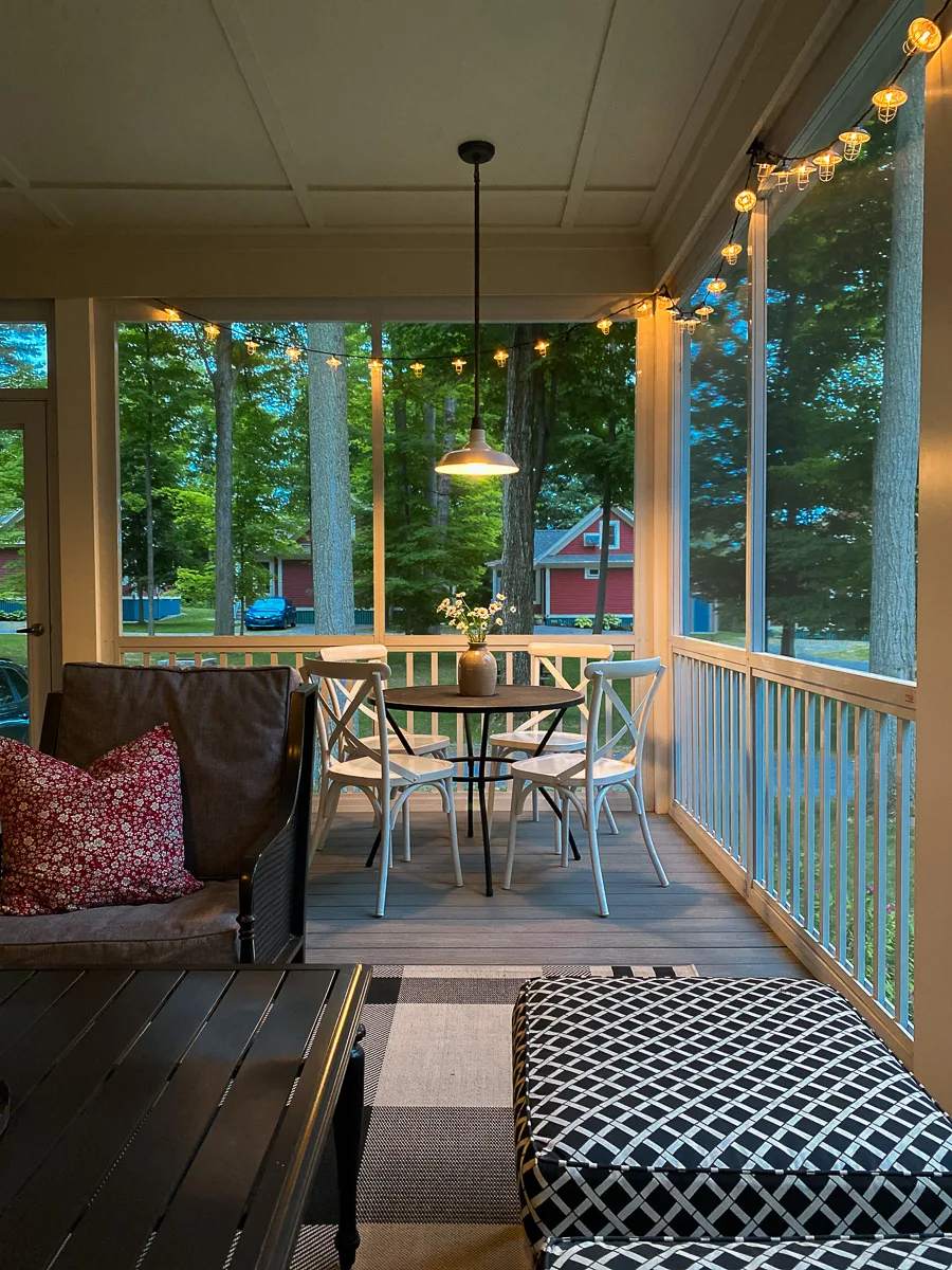screened in porch with round dining table and pendant light
