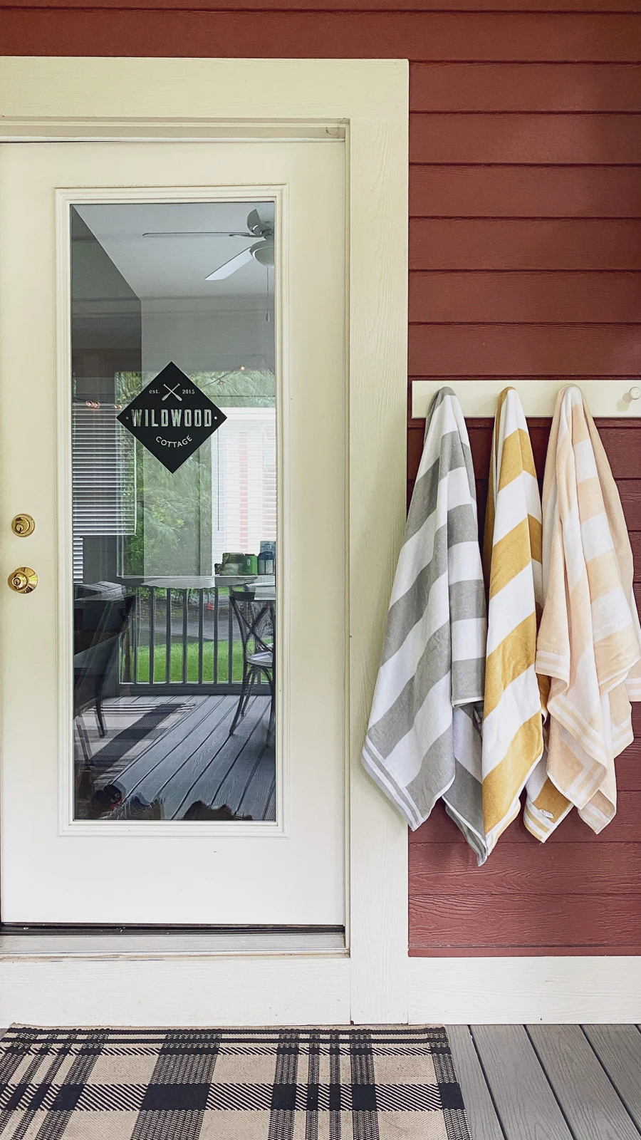 red cottage decor with door decal and plaid outdoor mat