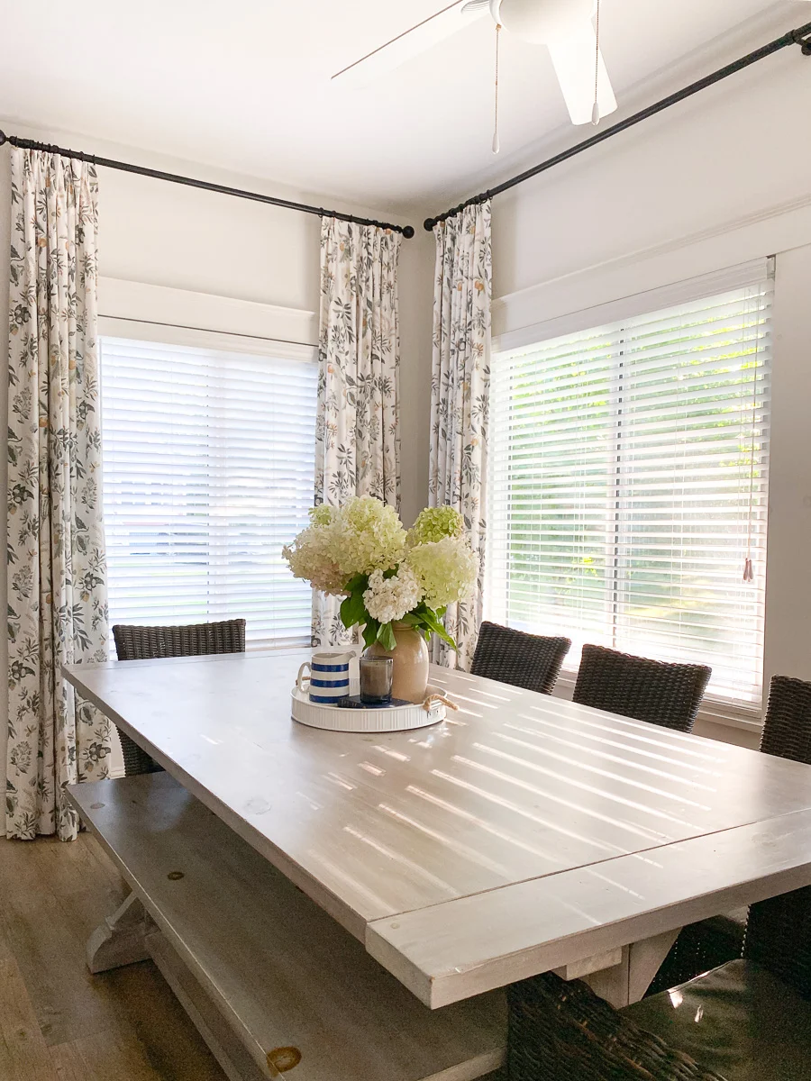 farmhouse table x-base dining room with floral curtains