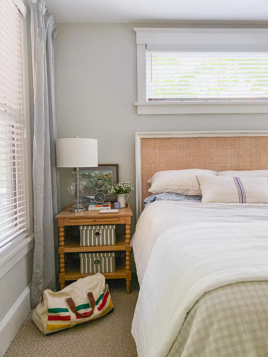 white cottage bedroom with spool side tables and rattan headboard