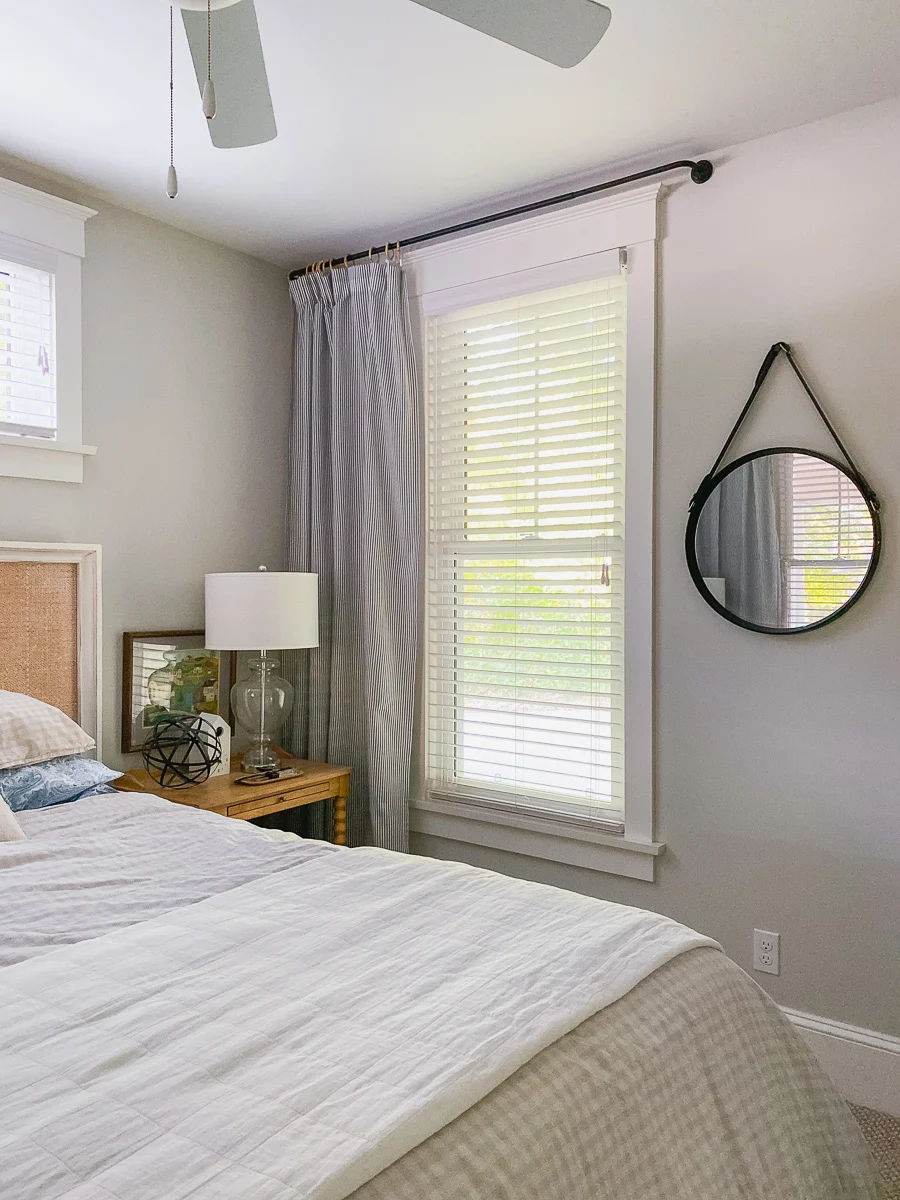 white cottage bedroom with spool side tables and rattan headboard
