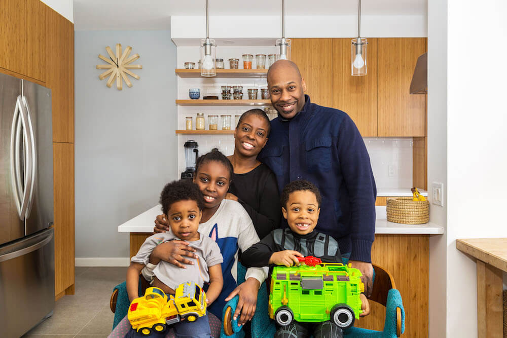Portrait of Tracy and family in front of the new kitchen