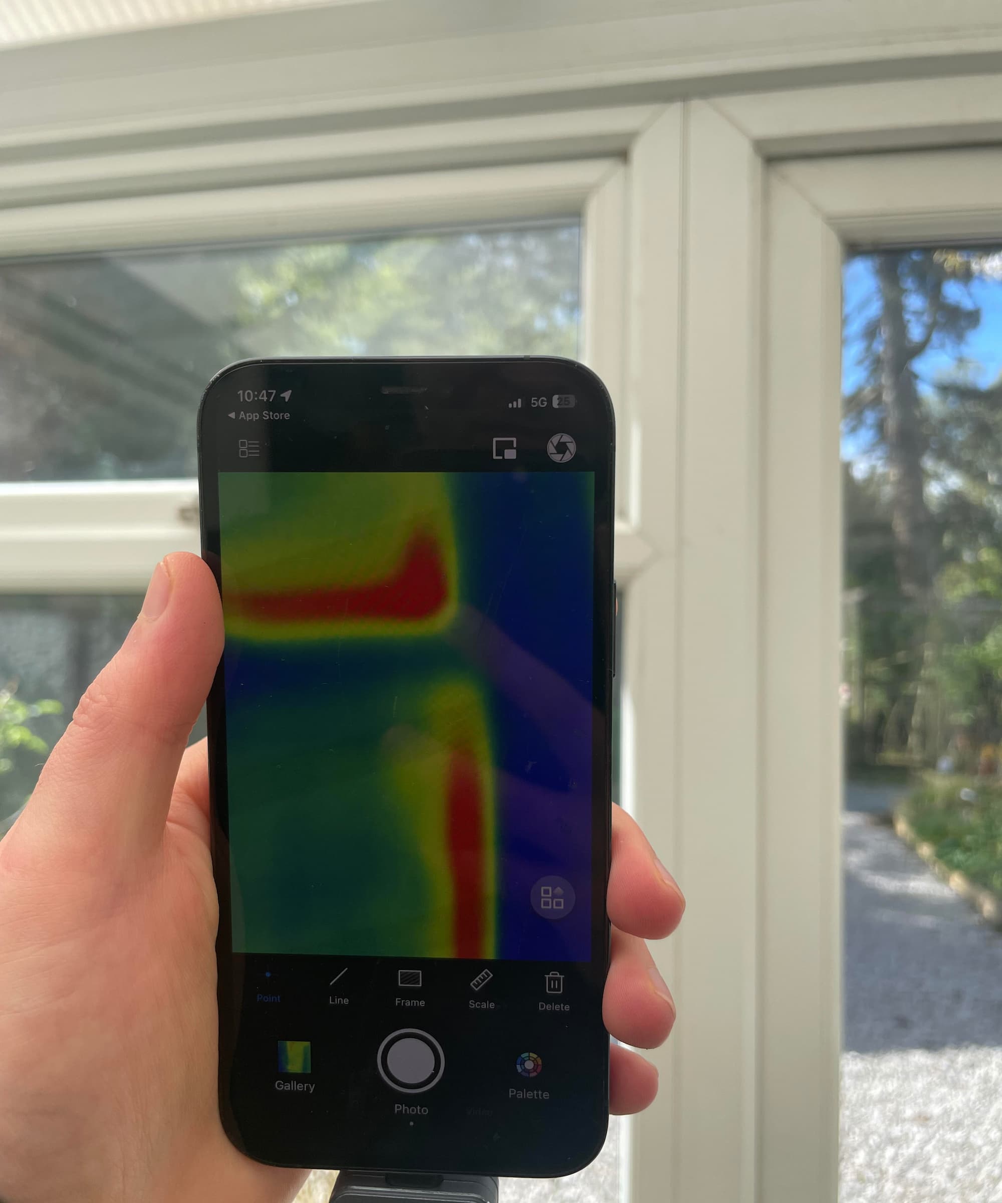 A white conservatory window revealing to lose heat using a thermal camera