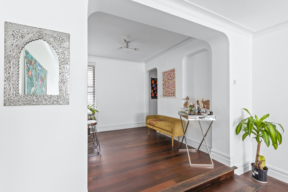 Brown laminate wood flooring with beige bench and side stool