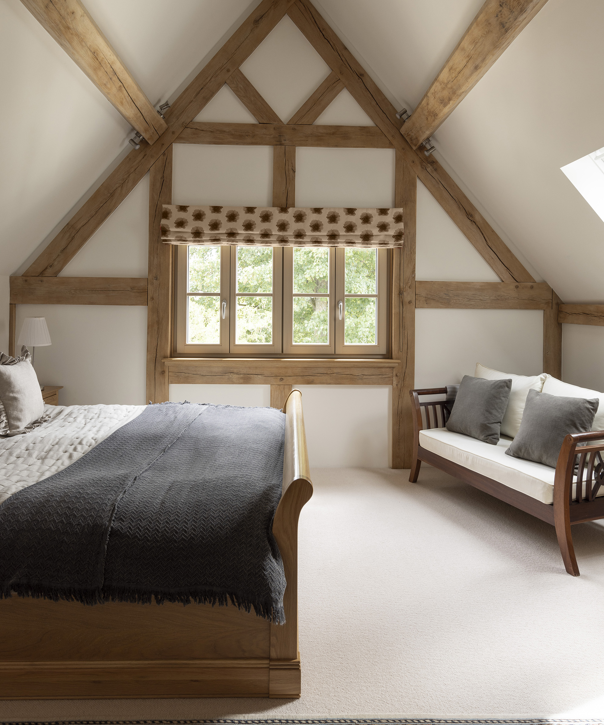 A master bedroom in the second floor of an oak frame build. The timber frame is exposed 