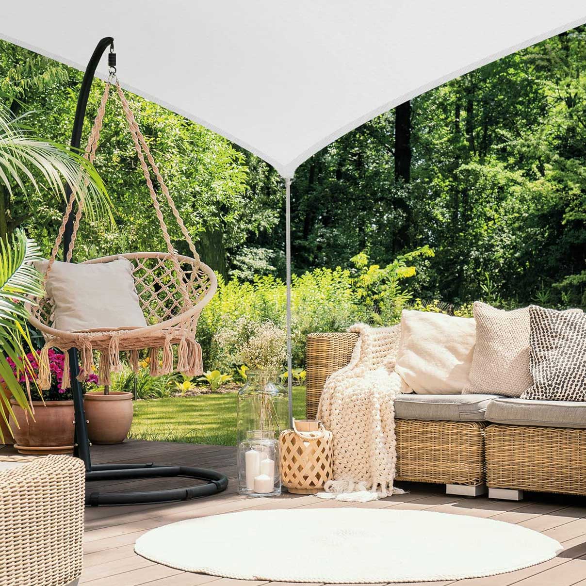 shade sail covering deck with garden furniture set, planting and small tree, and patio doors in background