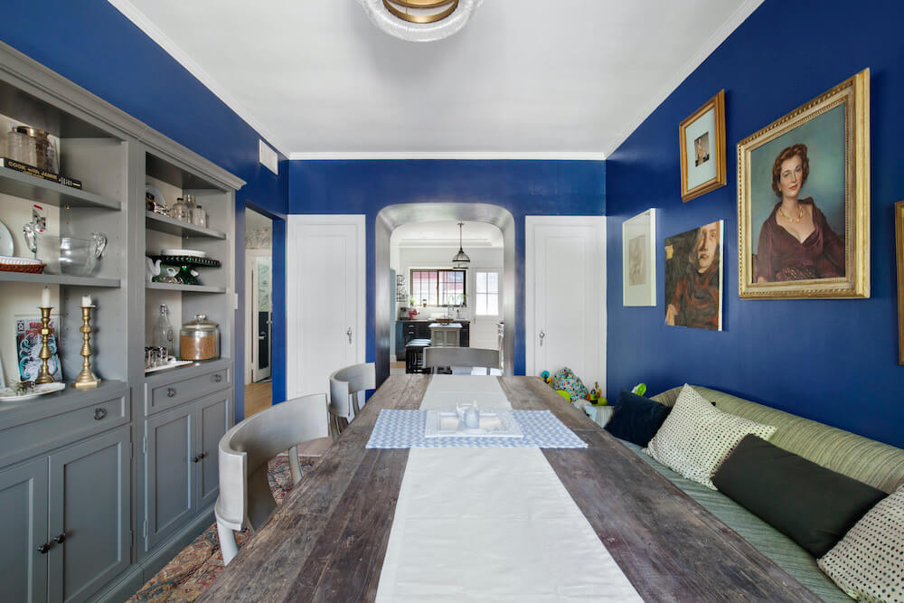 Dining room area with blue wall paint and gray cabinets after renovation