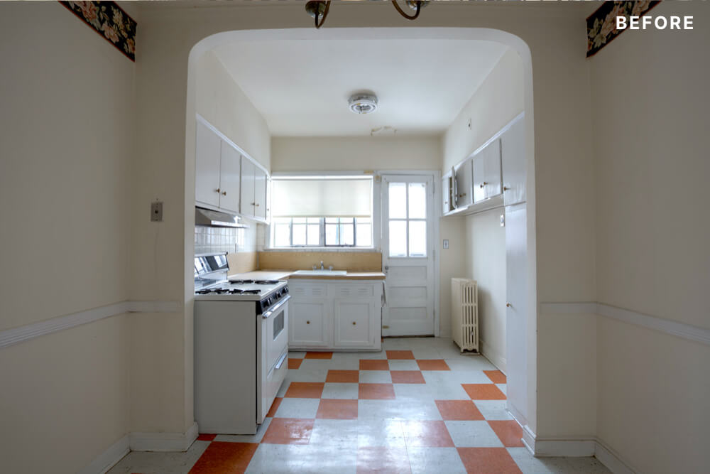 White kitchen with cabinets on white and orange tiles before renovation
