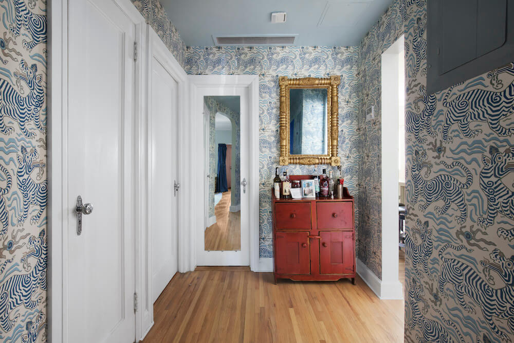 Hall area with white doors and blue tiger wall paper after renovation
