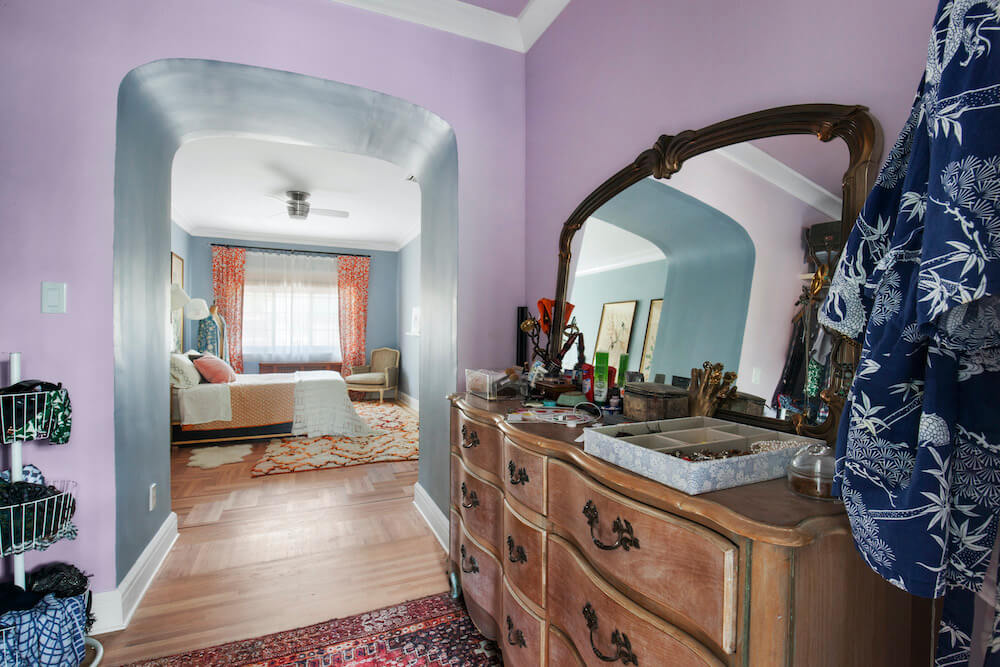 Vintage styled dresser in a bedroom with arched entryway before renovation