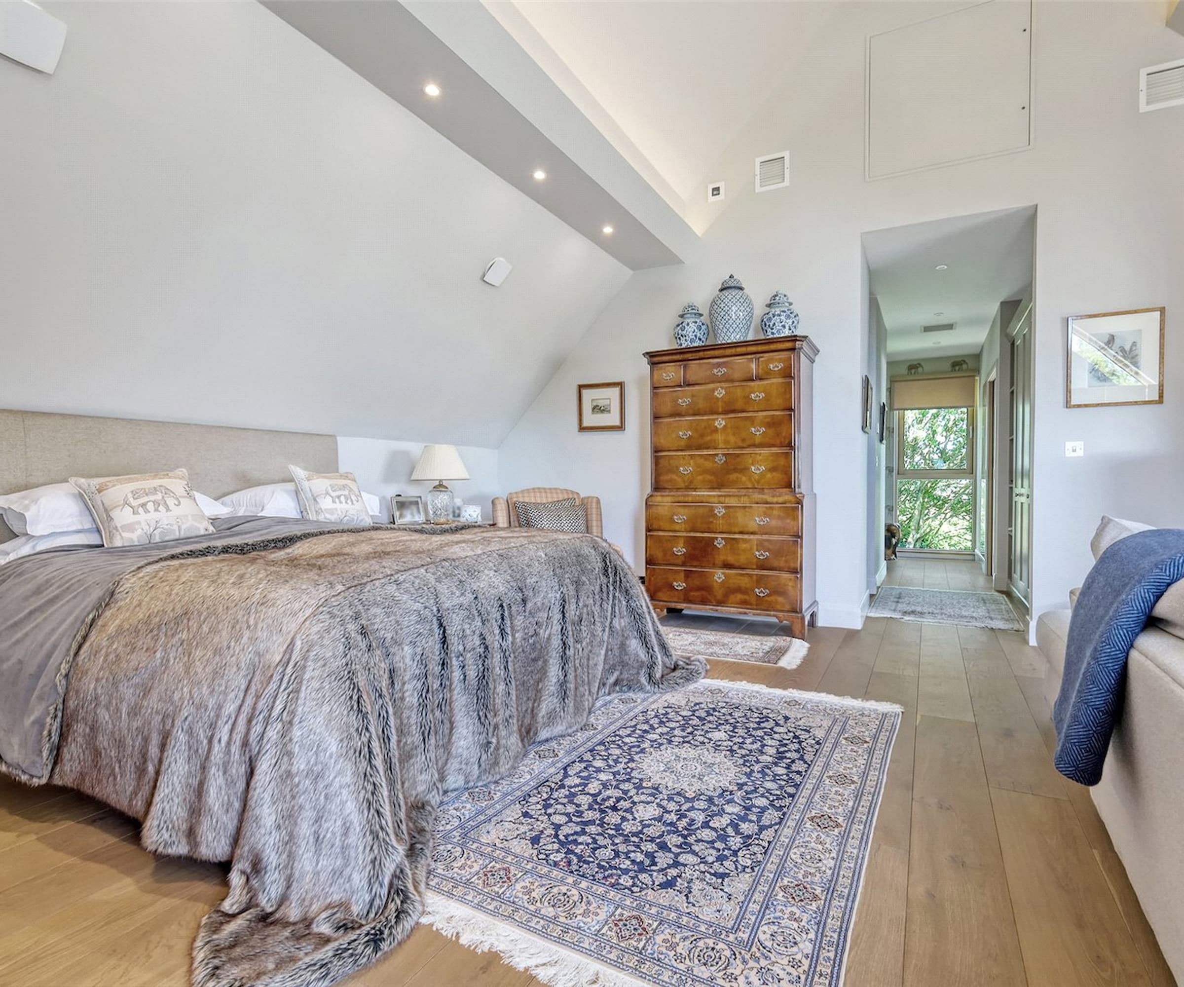 A bedroom with a slanted ceiling and a sofa