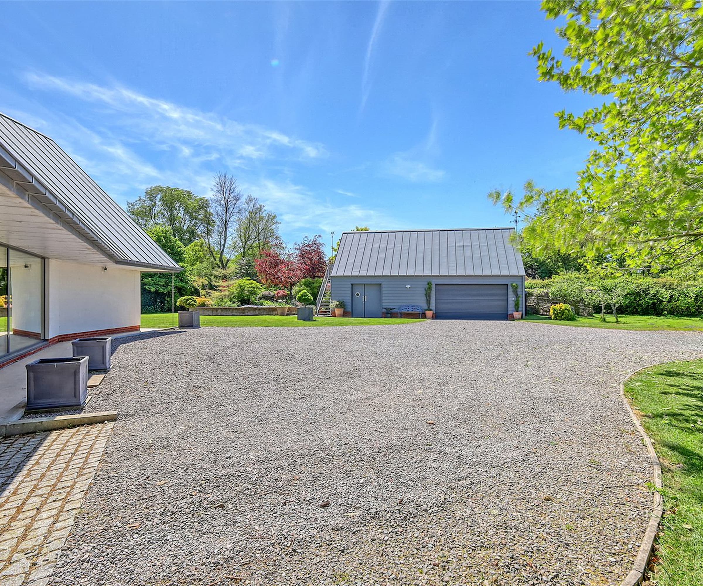 A gravelled driveway and a grey garage
