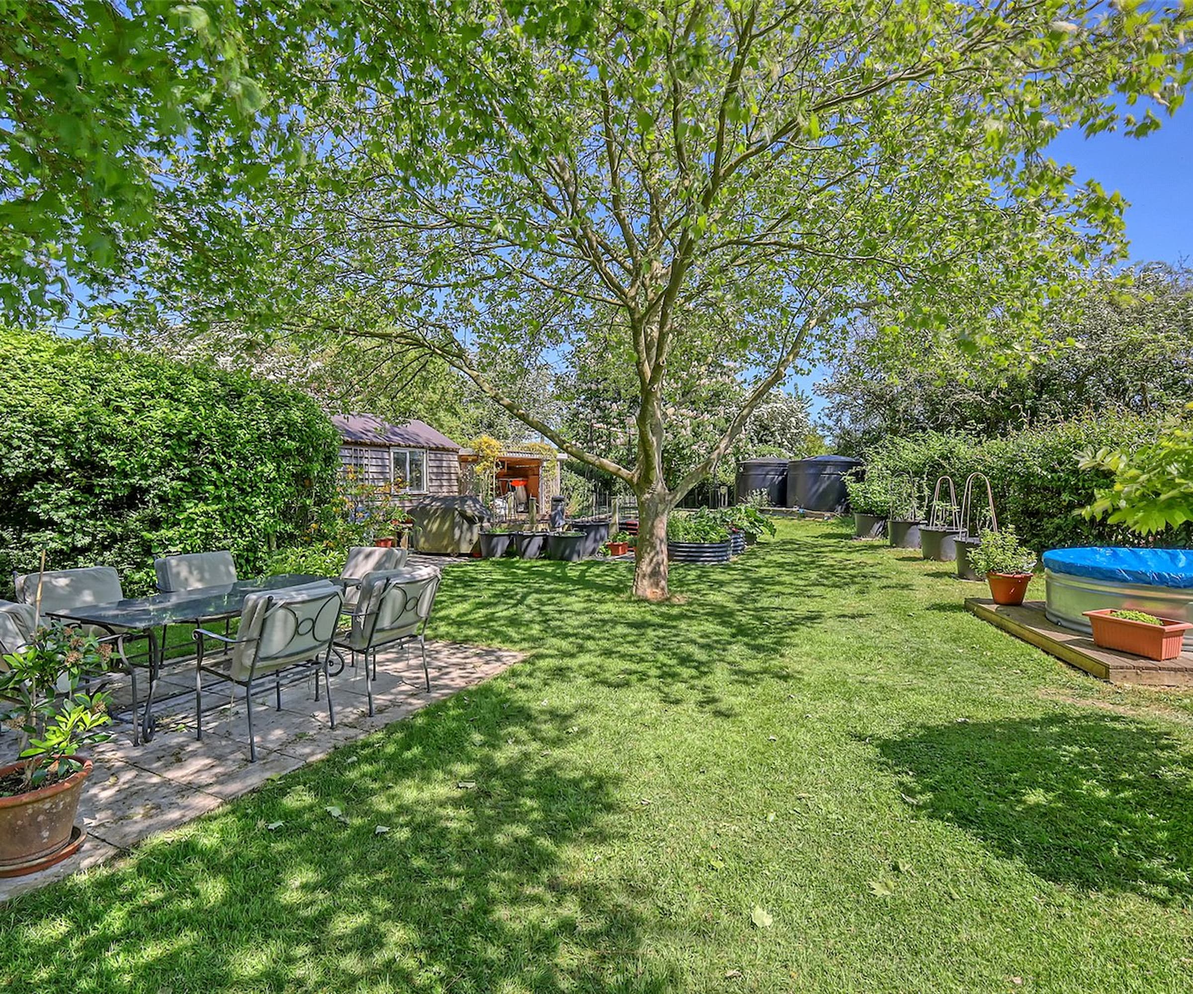 A garden with an above ground swimming and an outdoor seating area