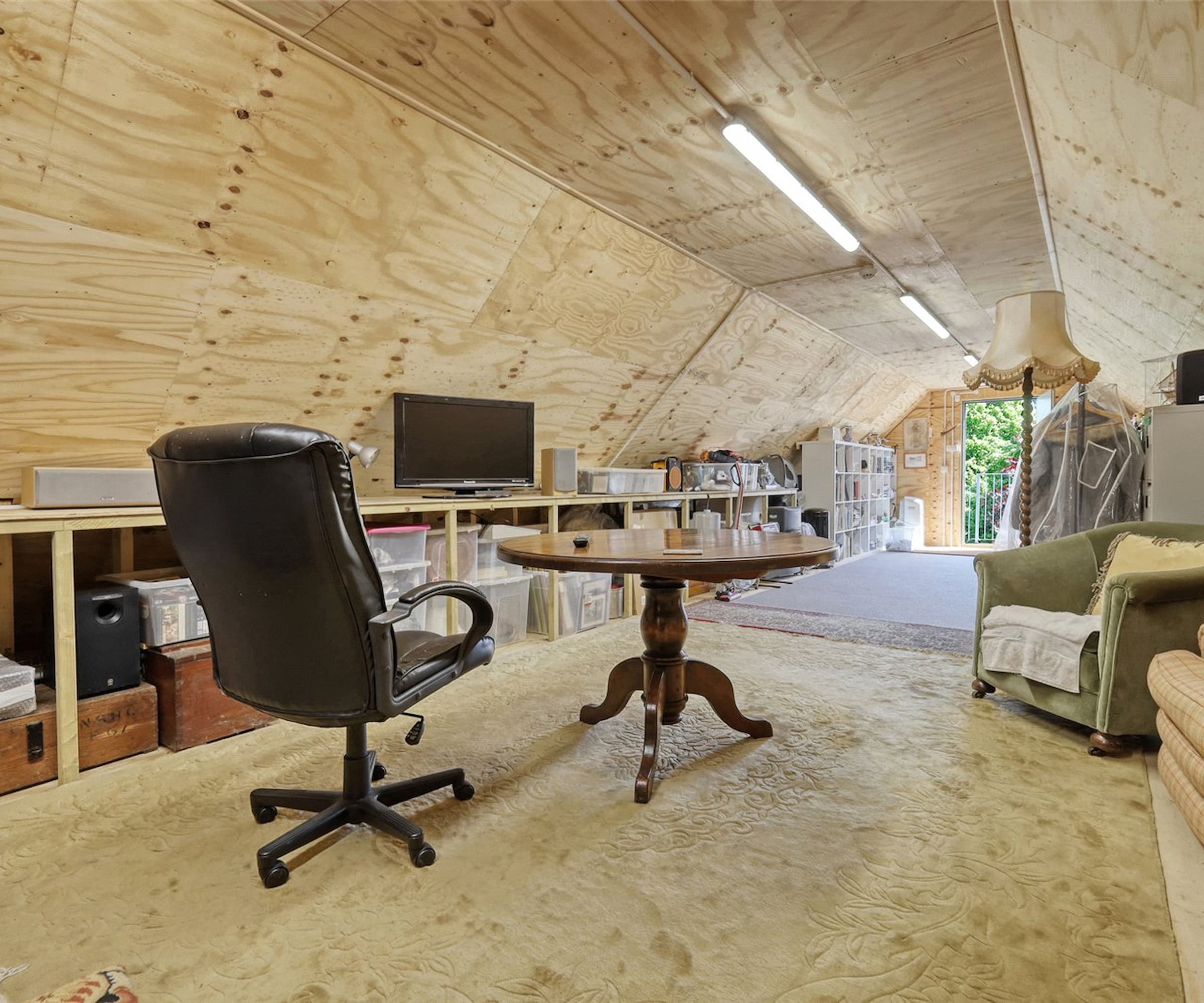 A wooden loft with office space with a round wooden table