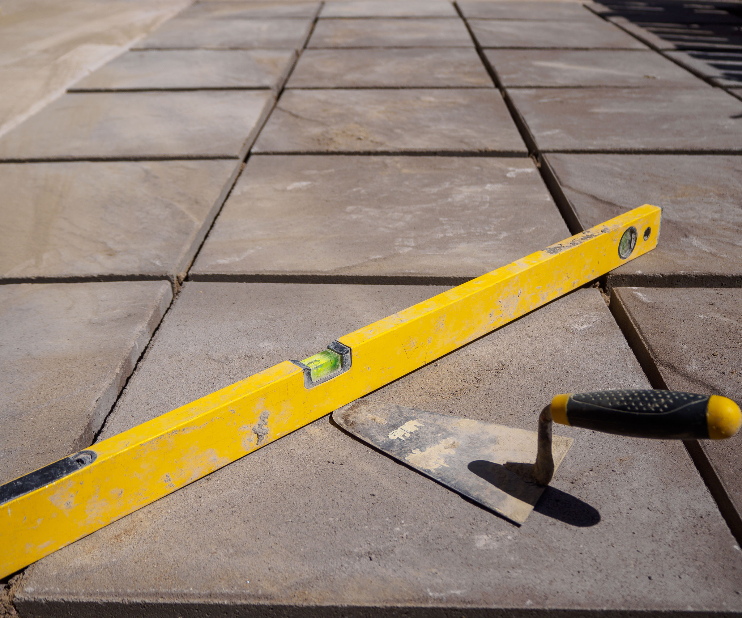 patio slabs with spirit level and trowel