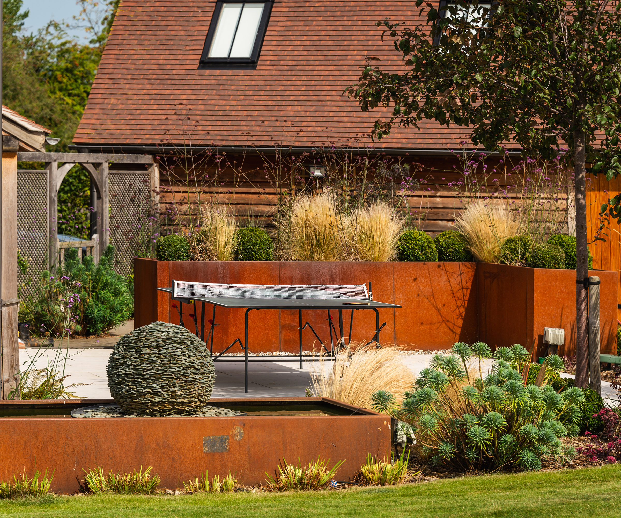 Corten steel raised planters  in a landscaped garden 