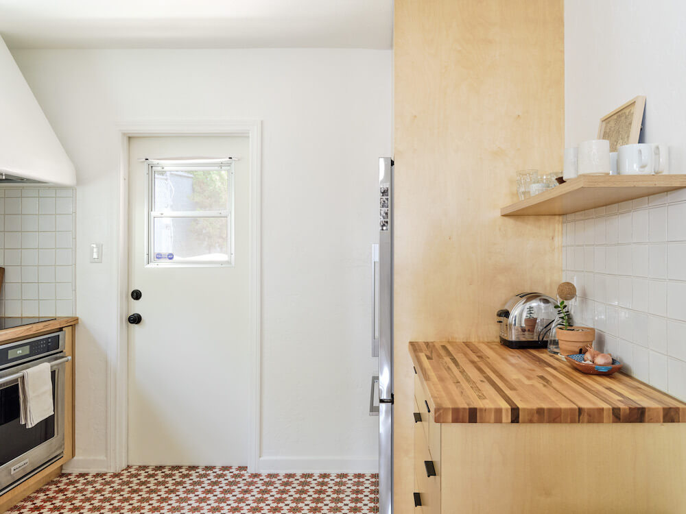kitchen with golden oak cabinets and stainless steel appliances and patterened floor tiles after renovation