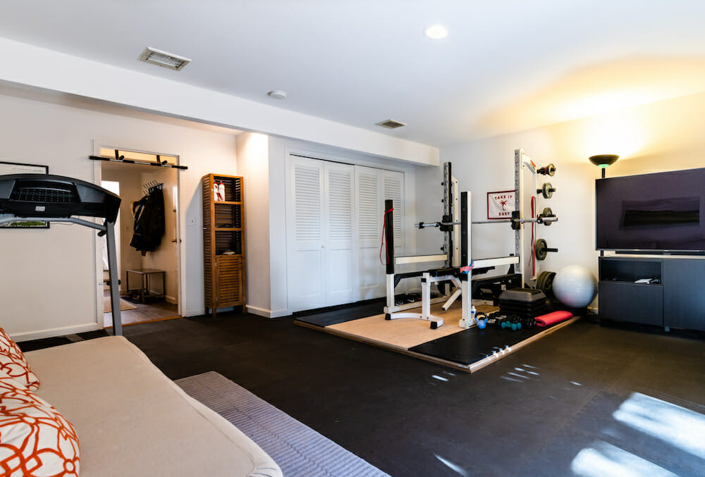 white walls in a home gym with equipments and black floor after renovation