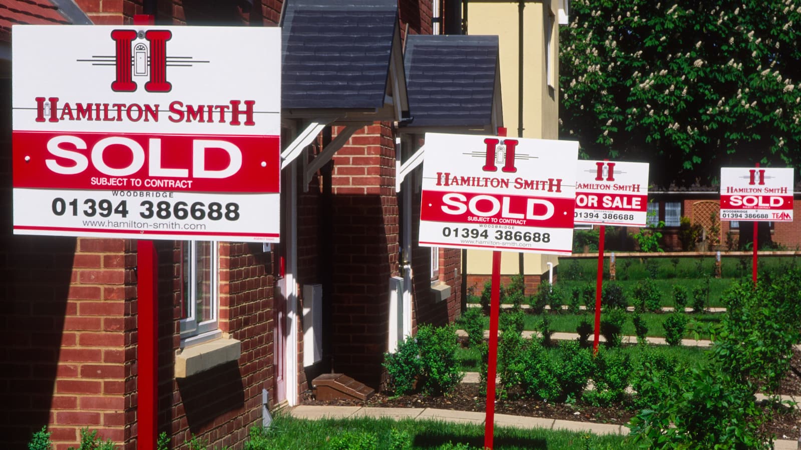 Property market estate agent signs saying Sold outside new housing, Rendlesham, Suffolk, England