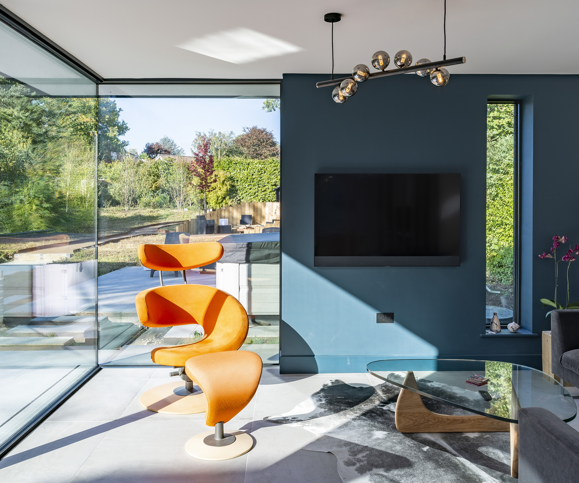 A glazed extension with lots of glass and natural light. There were peacock blue paint and orange furniture