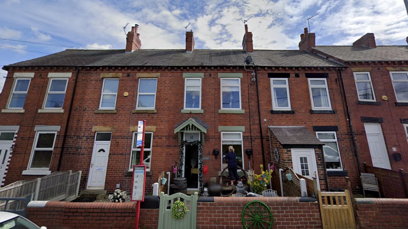A brick house decorated with ornaments and a green front gate