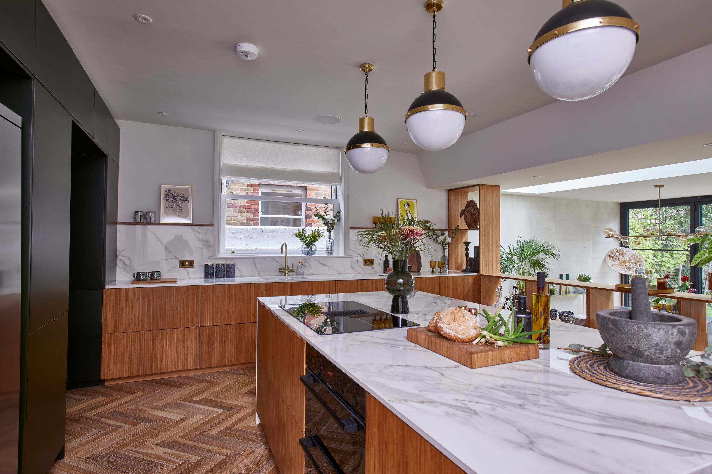 The kitchen has white marble worktops and wooden cabinets