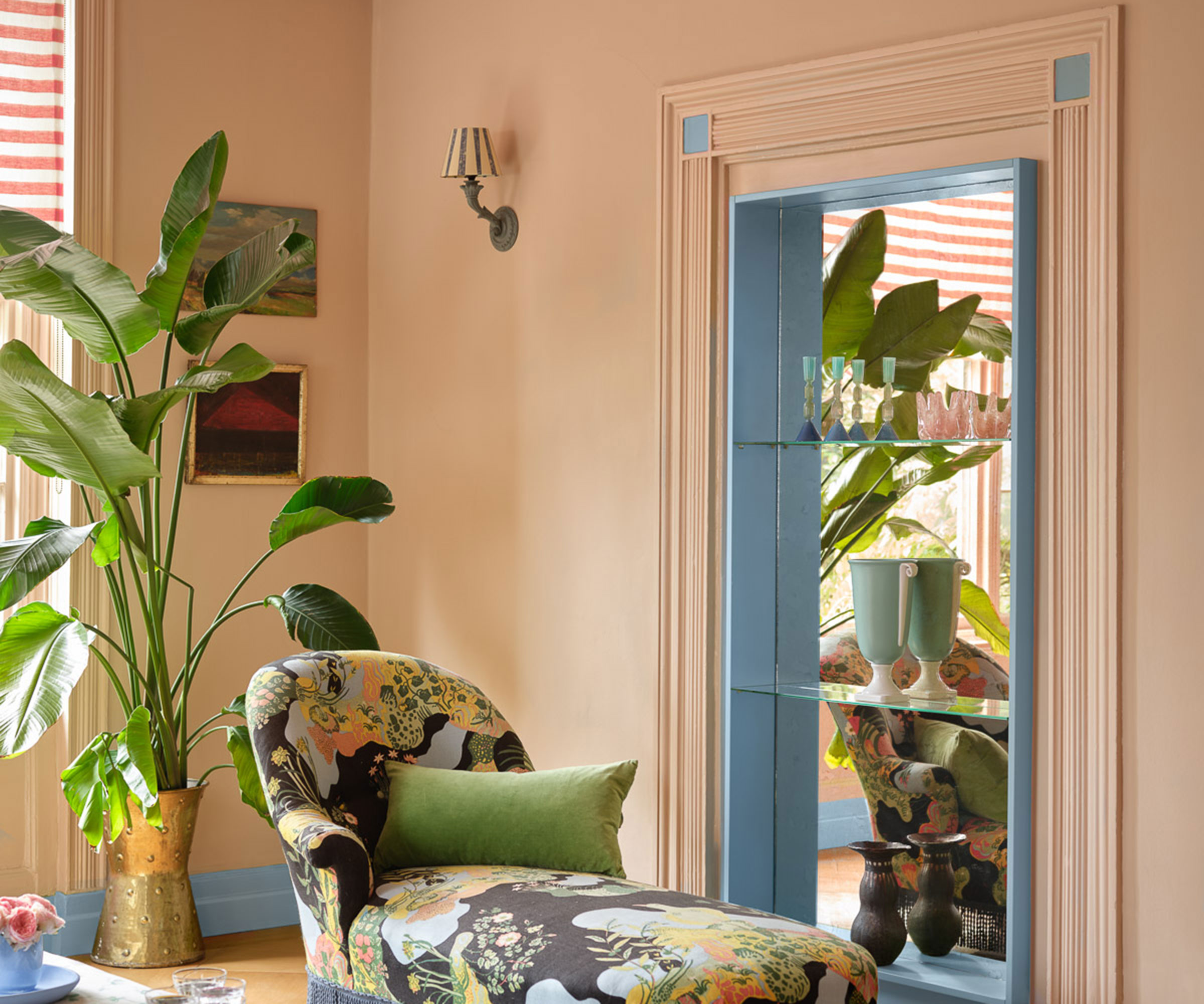 living room with patterned chaise longue and coral walls with blue painted woodwork