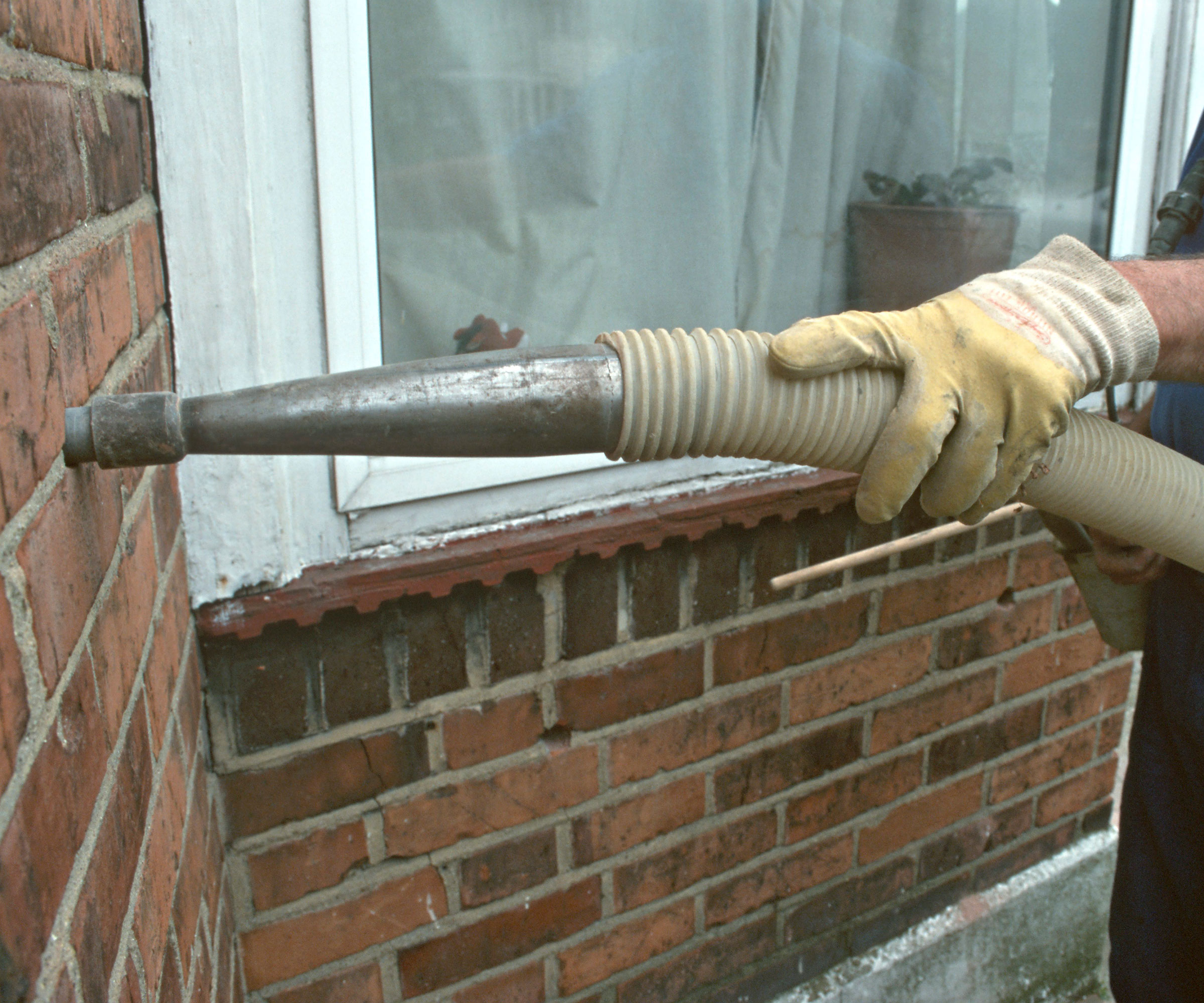 cavity wall insulation being blown in through external walls