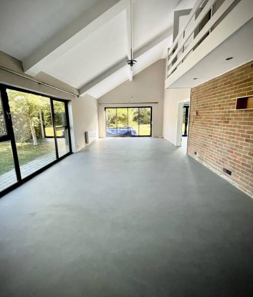 Examples of polished concrete and microcement floors. The polished concrete is shiny while the microcement is more textured