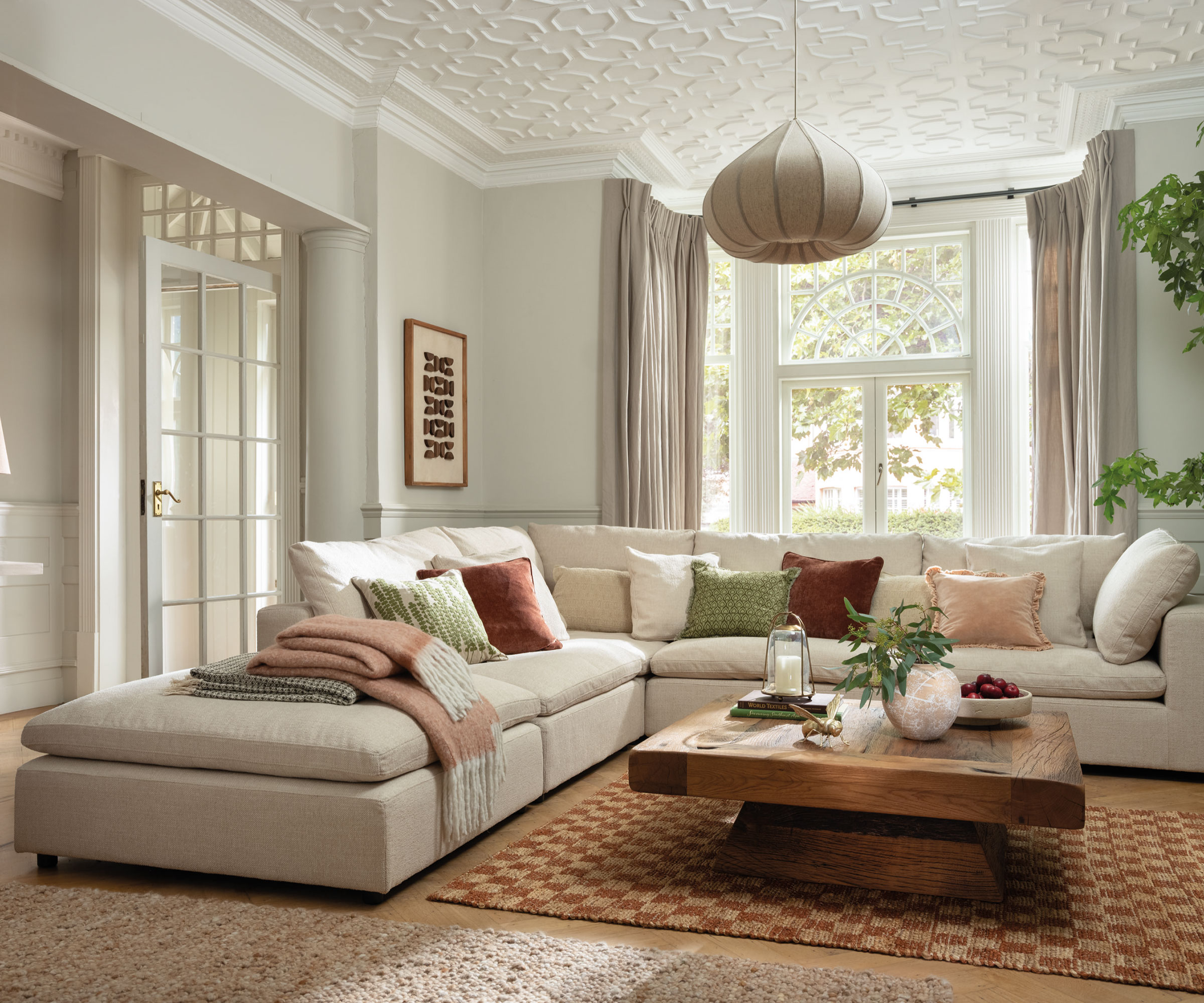 neutral living room with cream corner sofa and large windows