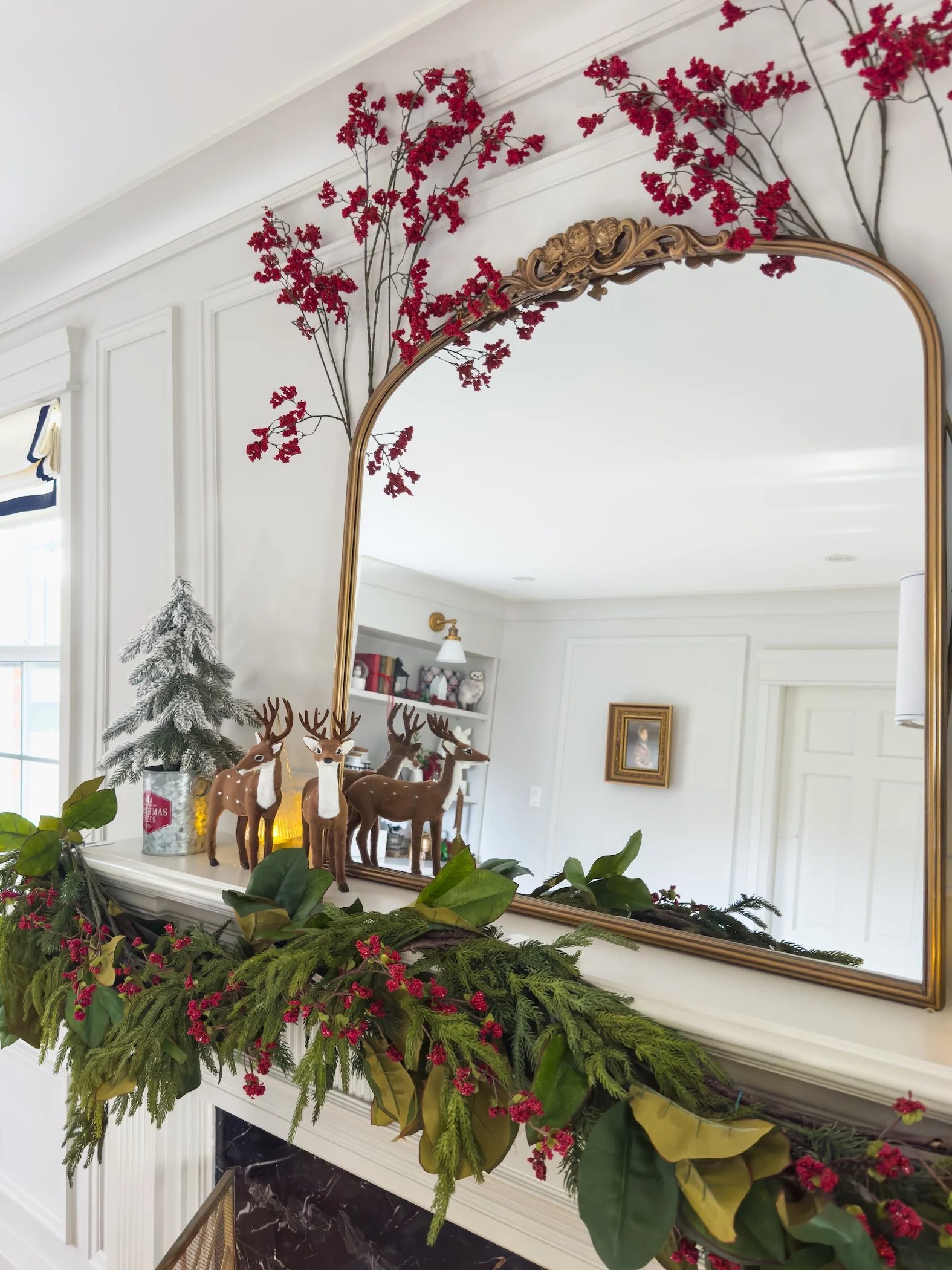 traditional fireplace mantel with garland mirror and red accents