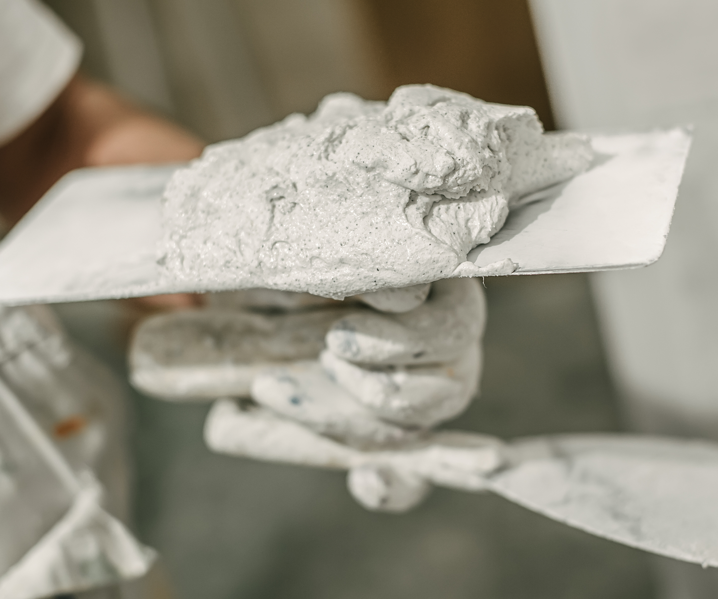 hand holding trowel and plastering tools