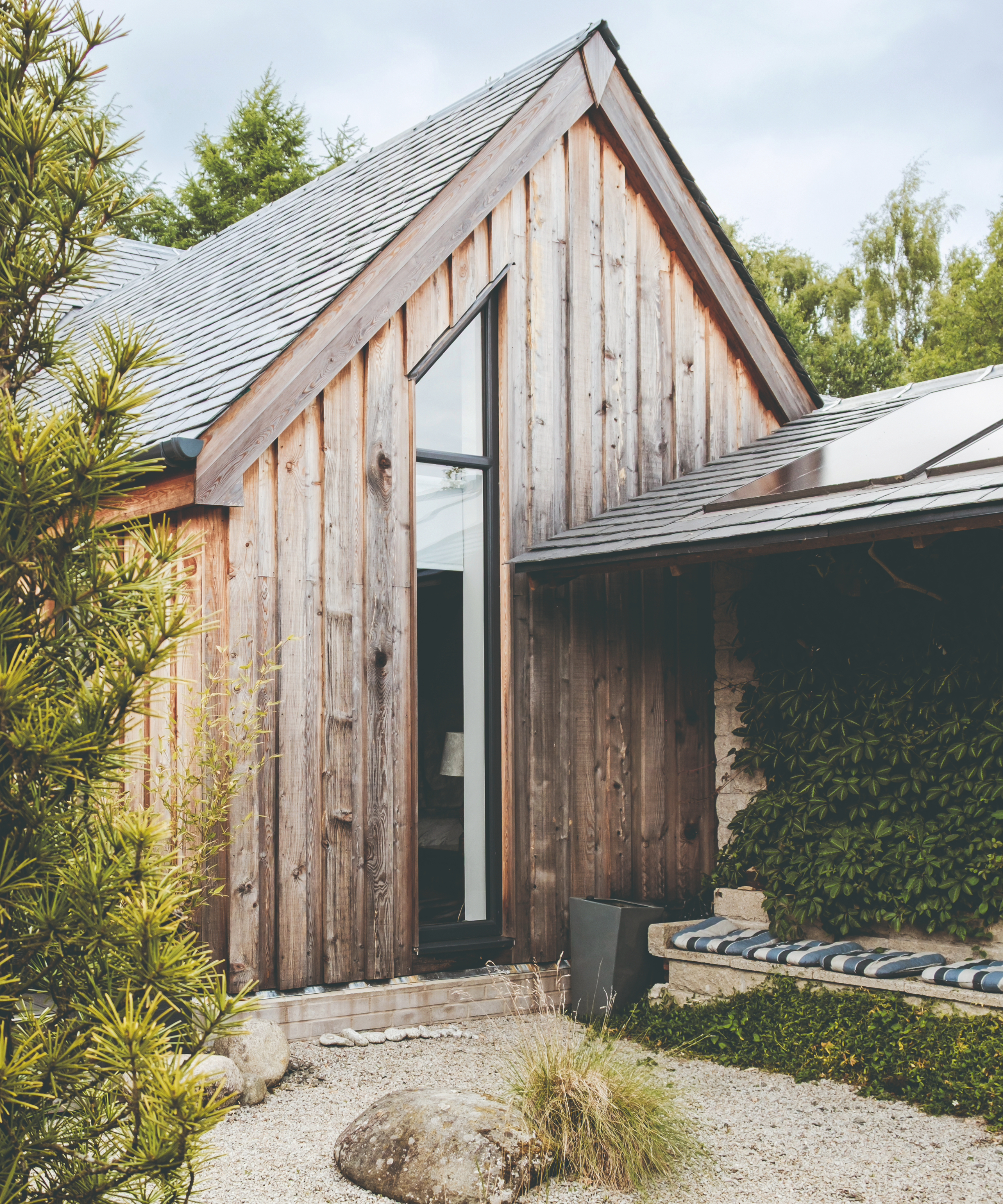 Exterior of the side of the house, with a bench seating area
