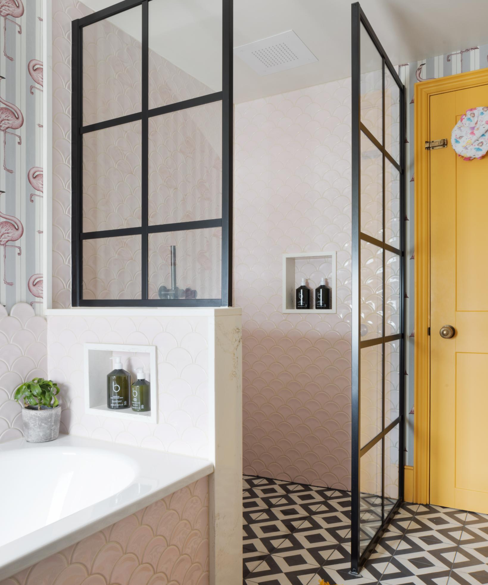 bathroom with variety of different tiles on walls and floor, bath, walk in shower and yellow door