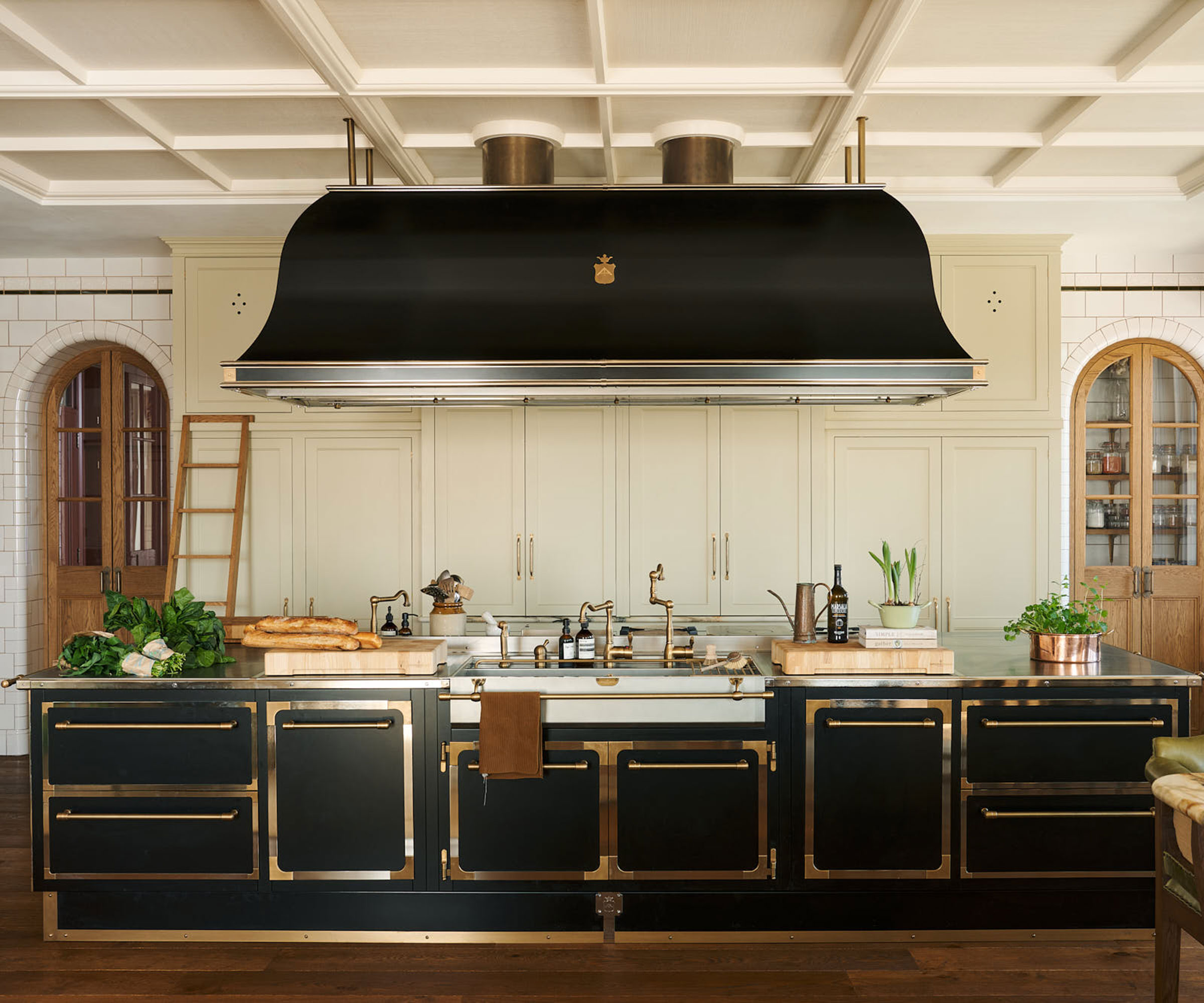 oversized black and gold kitchen island with matching extractor hood